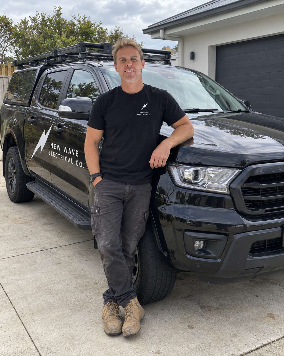 Aaron beside the New Wave Electrical Co work ute